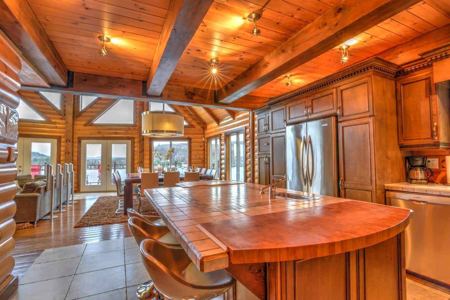 Cuisine avec îlot central et vue sur la salle à manger et le lac